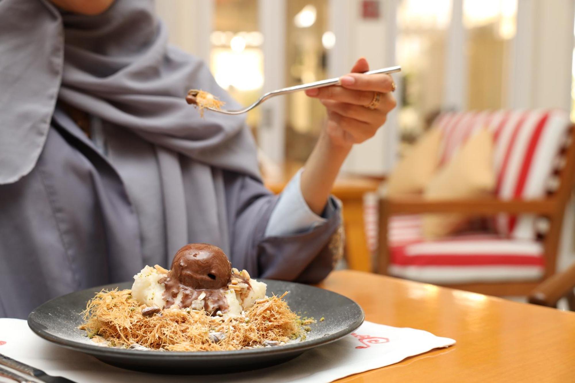 Kempinski Al Othman Hotel Al-Chubar Zewnętrze zdjęcie A woman eating a dessert